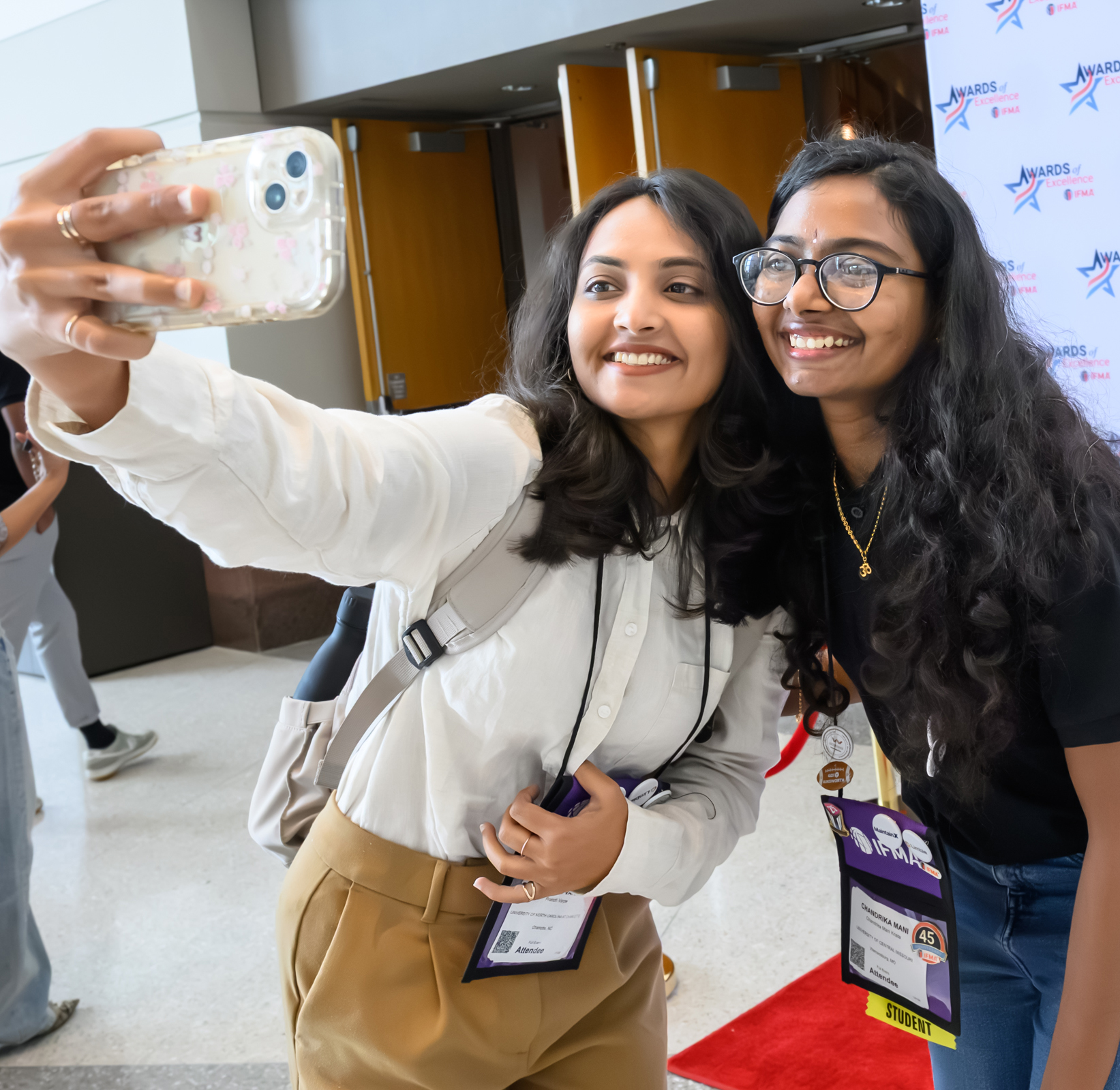 Two women attendees taking a selfie at IFMA’s Facility Fusion Conference & Expo, highlighting networking and customer connections. Two women attendees taking a selfie at IFMA’s Facility Fusion Conference & Expo, highlighting networking and customer connections.